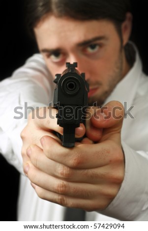 young man in white shirt aiming down on his weapon, focus on gun barrel