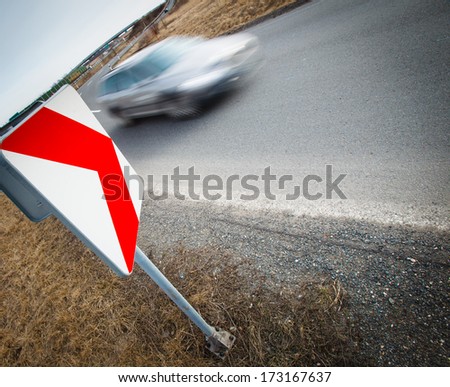 Traffic concept: car driving fast through a sharp turn (motion blur is used to convey movement)