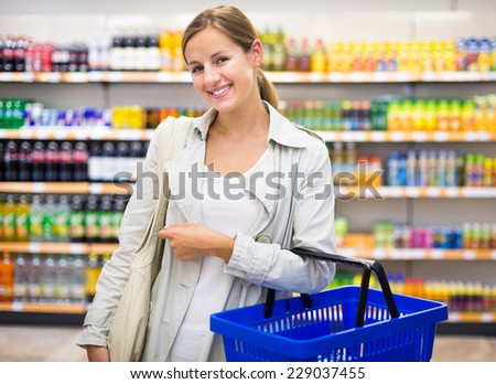 Pretty young woman buying groceries in a supermarket/mall/grocery store (color toned image; shallow DOF)