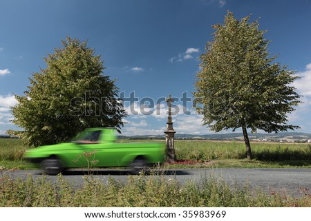 Motion blurred car rushing through a lovely summer scenery