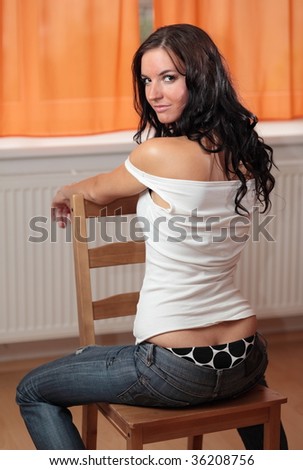 Alluring brunette wearing posing on a chair