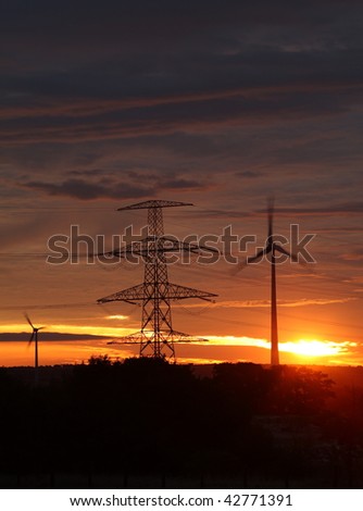 wind energy harvesting wind mills at sunrise
