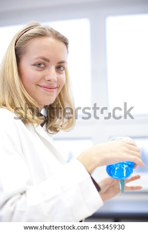 Portrait of a pretty female researcher carrying out experiments in a lab