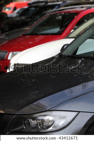 automotive concept - row of cars parked in a street (no identifiable trademarks)
