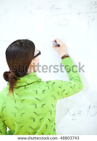 young female college student in front of a whiteboard during a math class
