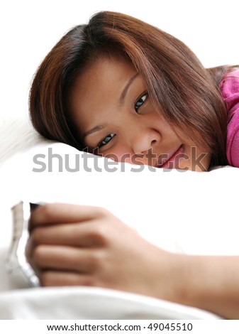 Insommnia - young asian woman looking at her watch, unable to fall asleep