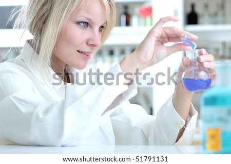 Closeup of a female researcher holding up a test tube and a retort and carrying out some experiments
