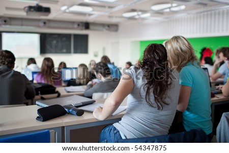 stock photo young pretty female college student sitting in a classroom full of students during class 54347875