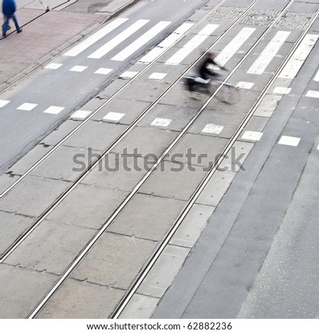 urban traffic concept - city street with a crossing, rail, motion blurred traffic