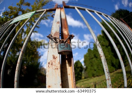 gate with padlock on a lovely autumn day(intentionally distorted image shot with a fisheye lens)