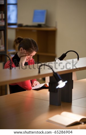 pretty female college student in a college library (shallow DOF; color tuned image)