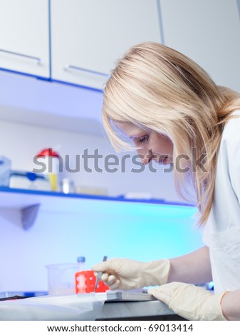 portrait of a female researcher doing research in a chemistry/biochemistry lab (color toned image; shallow DOF)