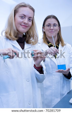 Two female researchers carrying out research in a chemistry/biochemistry lab (color toned image)