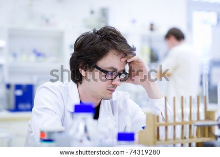 young male researcher carrying out scientific research in a chemistry lab (shallow DOF; color toned image)