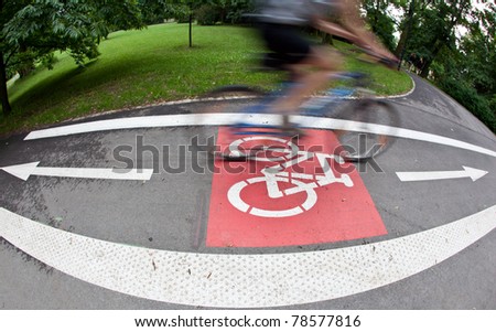 biker on a biking path in a city park (motion blur is used to convey movement)