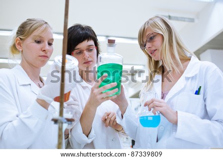 portrait of female researchers/chemistry students carrying out research in a chemistry lab (color toned image; shallow DOF)