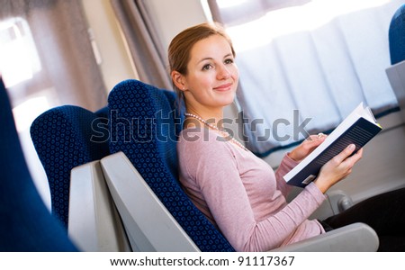 Young woman reading a book while on a train