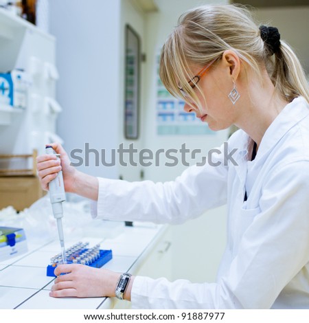 female researcher carrying out research experiments in a chemistry lab (color toned image)