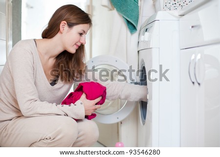 Housework: young woman doing laundry (shallow DOF; color toned image)