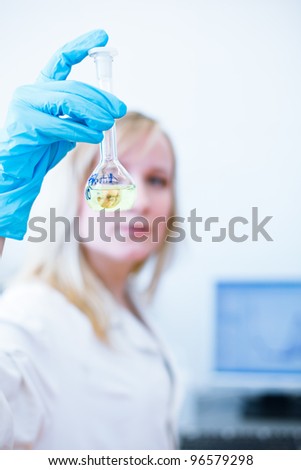 Closeup of a female researcher/chemistry student carrying out experiments in a lab (color toned image)