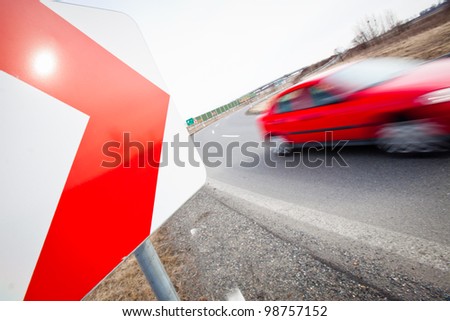 Traffic concept: car driving fast through a sharp turn (motion blur is used to convey movement)