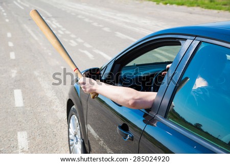 Driver with a baseball bat on the road