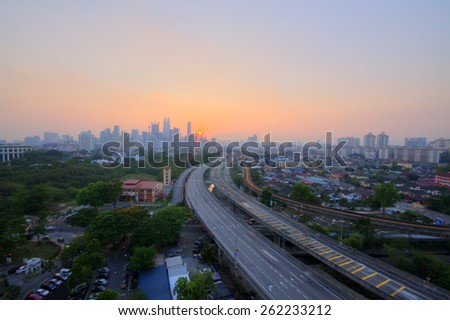 Highway to Kuala Lumpur city during sunset\
Image has grain or blurry or noise and soft focus when view at full resolution. (Shallow DOF, slight motion blur)
