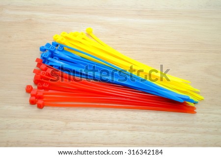 self-locked plastic zip cable ties in different colors on a wooden background