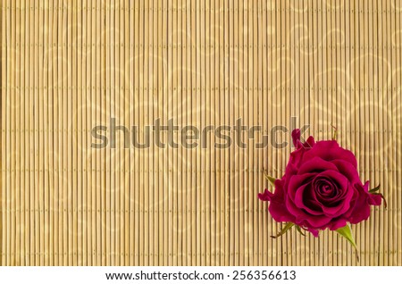 Wood, wicker background with red rose flower