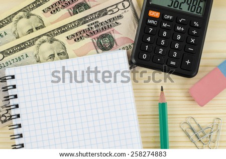 Office, business tools with dollars and calculator on wooden table
