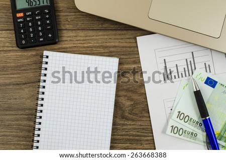 Office, business tools with notebook and euro on wooden table