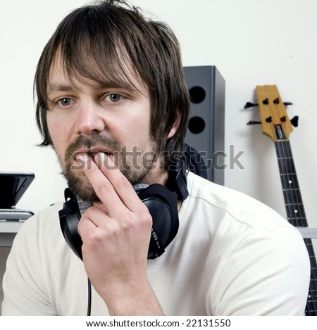 young male holds hands to mouth with music kit behind