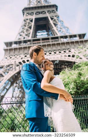 Lovers in Paris, a romantic walk through Paris in a beautiful wedding dress. Against the background of the Eiffel Tower