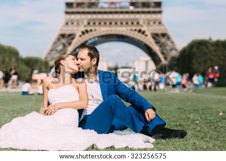 Lovers in Paris, a romantic walk through Paris in a beautiful wedding dress. Against the background of the Eiffel Tower