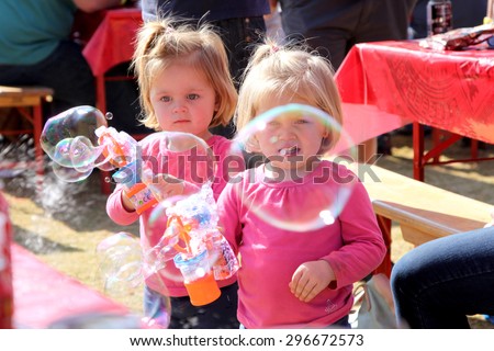 THABAZIMBI, SOUTH AFRICA - JUNE 28: Two Small Sisters Playing with Bubble Makers at Wildsfees (Game Festival) on June 28, 2014 in Thabazimbi South Africa.