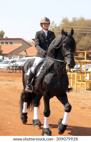 THABAZIMBI, SOUTH AFRICA - August 1:  Friesian horse show at Thabazimbi Agricultural Show, on August 1, 2014 at Thabazimbi, South Africa. Young girl riding lovely black Friesian horse.
