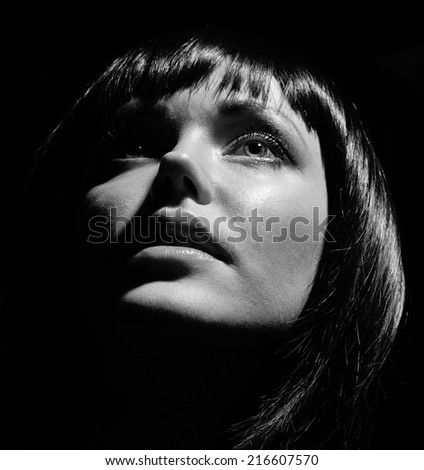 Portrait of a girl on a black background..Black-and-white photo.