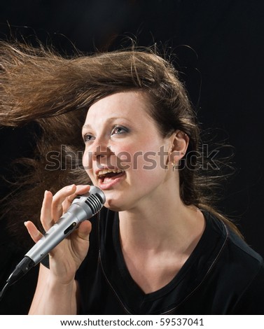 singer with a microphone singing a song.woman on a black background