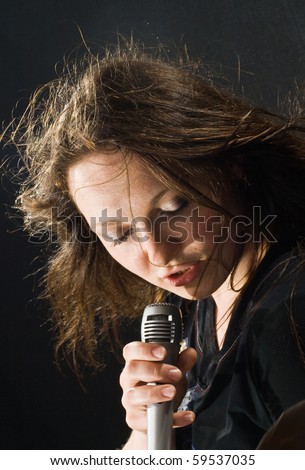 singer with a microphone singing a song.woman on a black background