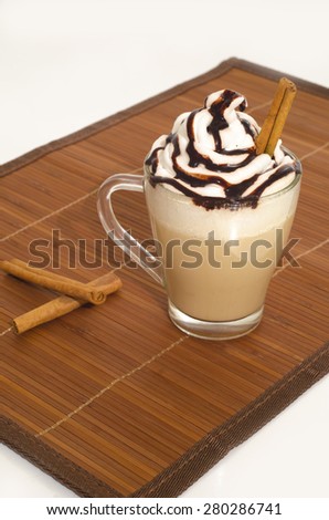 Iced coffee with foam and cinnamon  on wooden background