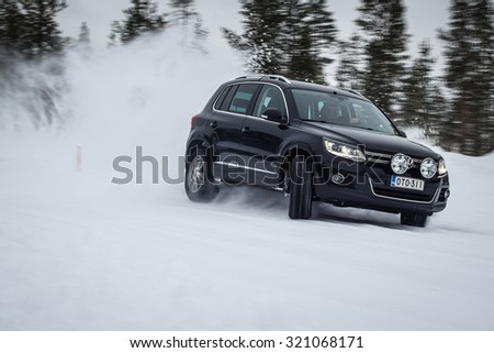 IVALO, FINLAND - February 15, 2015: Winter tire test is held at the proving ground. Test-driver performs snow handling test to determine the tire which provides the best grip on snow. SUV on display.