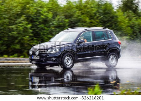 NOKIA, FINLAND - September 15, 2015: Tire test is held at the proving ground. Professional test-driver performs a wet handling test to determine the tire which provides the best grip with wet road.