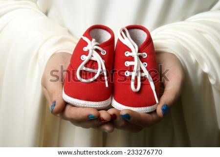 A mother embraces her childs shoes to welcome a new beginning.