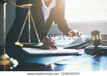 Justice and Law concept. Legal counsel presents to the client a signed contract with gavel and legal law or legal having team meeting at law firm in background 商業照片 © 
