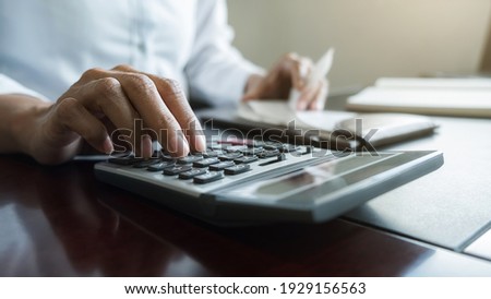 Woman with bills and calculator. Woman using calculator to calculate bills at the table in office. Calculation of costs.