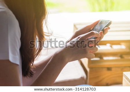 Woman using mobile smart phone. vintage tone Retro filter effect,soft focus,low light.