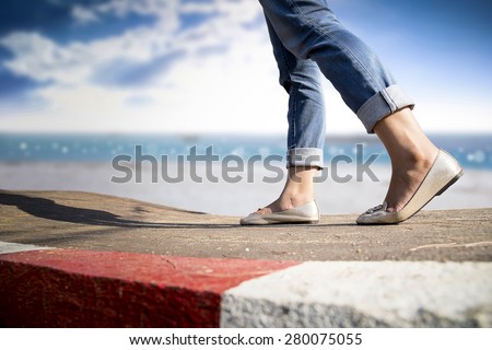 woman walking on the road and beach side background