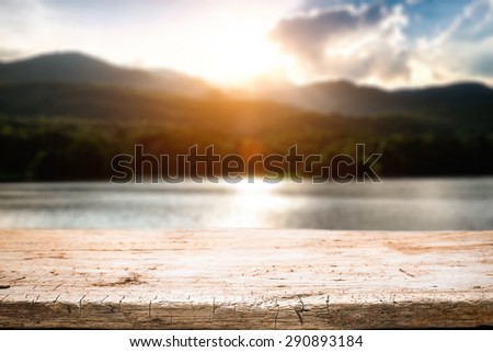 desk space and beautiful river with mountains and sun set background