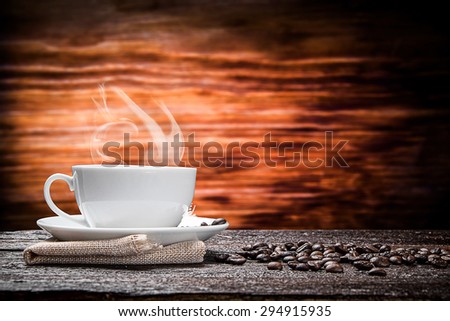 warm cup of coffee on brown wood background