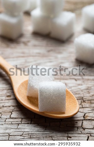 sugar in wood spoon on old wood table